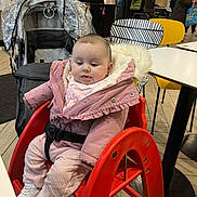 Summer is registered to the contest to win money with this photo: baby, cafe, casual_clothing, chair, child, conversation, curious, flooring, footwear, high_chair, indoor, modern, people, pink_jacket, public_space, seated, stroller, table, winter_clothing, wooden_floor
