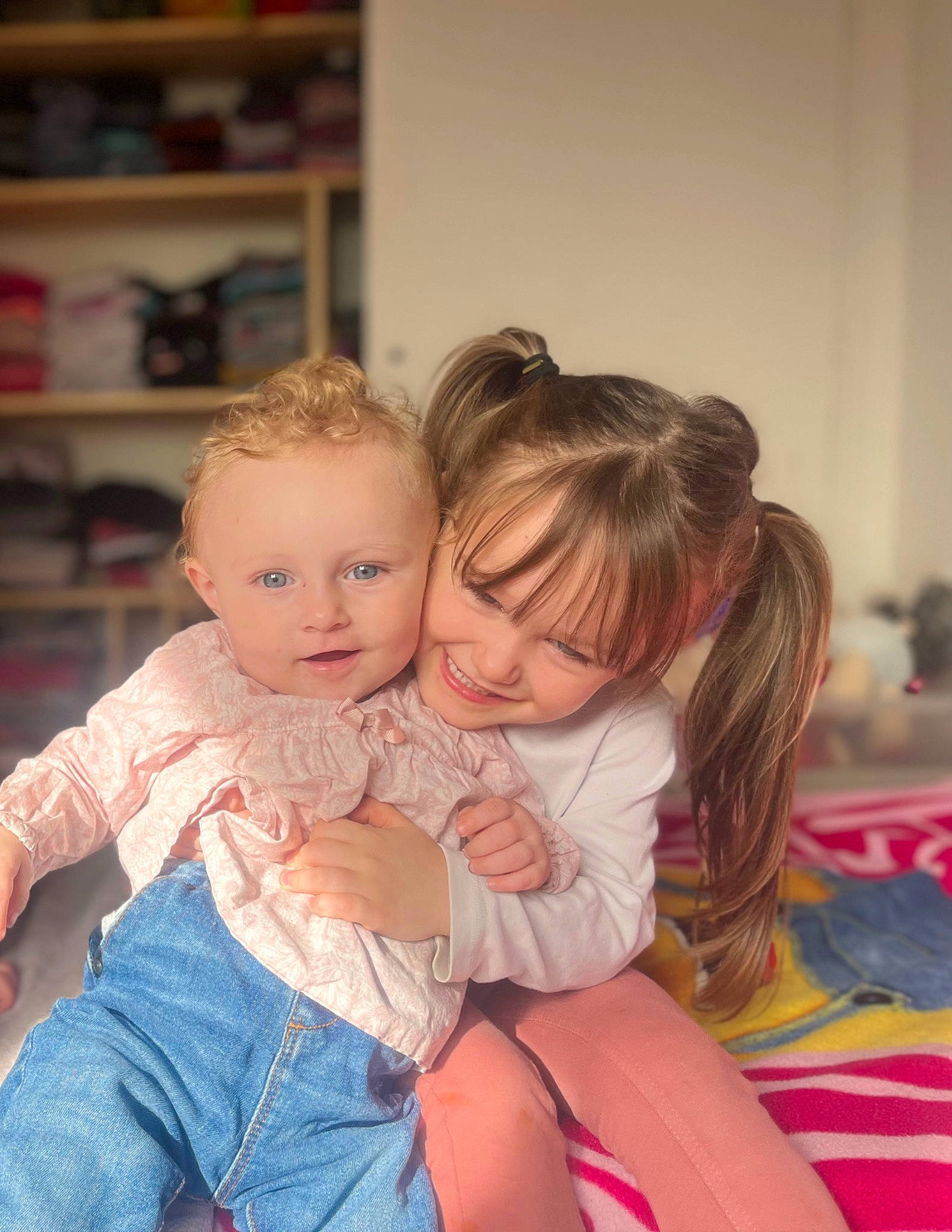 Lisa a rejoint le concours — aidez-le/la à gagner de superbes lots ! baby, baby_toddler_clothing, blond, bookcase, cheek, child, comfort, facial_expression, flooring, fun, happy, iris, joy, lap, person, shelf, shoulder, sitting, skin, smile