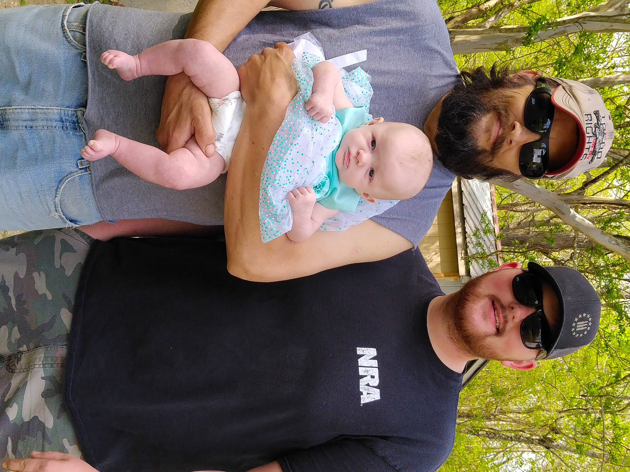 Willow is registered to the contest to win money with this photo: baby, clothing, comfort, event, eyewear, face, fun, gesture, goggles, grass, green, happy, headwear, joy, lap, leisure, person, plant, recreation, sunglasses