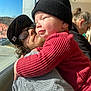 Bowen is registered to the contest to win money with this photo: baby, child, adult, glasses, hat, knit_hat, red_sweater, checkered_shirt, hugging, window, sunlight, indoor, people, beard, facial_hair, casual_clothing, portrait, smiling, person, seated