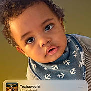 Emmanuel is registered to the contest to win money with this photo: toddler, child, curly_hair, face, blue_bib, striped_shirt, music_player, lock_screen, phone_screen, time_display, date_display, portrait, close_up, indoor, expression, young_child, eyes, head_tilt, casual_clothing, technology
