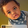 toddler, child, curly_hair, face, blue_bib, striped_shirt, music_player, lock_screen, phone_screen, time_display, date_display, portrait, close_up, indoor, expression, young_child, eyes, head_tilt, casual_clothing, technology