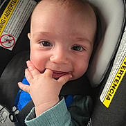 Jackson is registered to the contest to win money with this photo: adorable, baby, car_seat, child, closeup, clothing, cute, eyes, face, hand, happy, indoor, infant, person, portrait, safety, seatbelt, smiling, warning_label, young_child