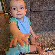 Jackson joined the competition — help win amazing prizes! baby, toddler, child, blue_bib, toy, carpet, couch, indoor, hand, foot, curious, sitting, clothing, colorful_toy, light, home, floor, young_child, person, playtime