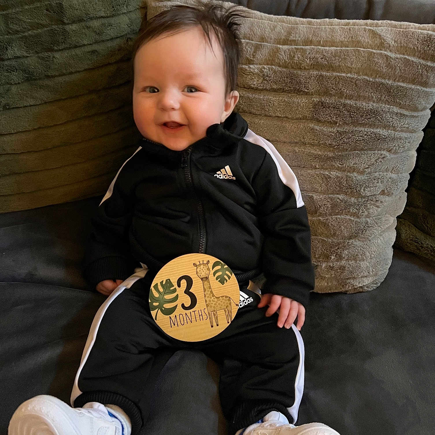 Kohen joined the competition — help win amazing prizes! baby, ball, clothing, coat, couch, cushion, face, football, footwear, furniture, head, homedecor, jacket, pants, person, photography, portrait, shoe, sitting, sneaker