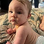 Ashton is registered to the contest to win money with this photo: baby, diaper, infant, child, blanket, leaf_pattern, skin, face, arm, hand, expression, indoor, person_in_background, table, furniture, curly_hair, light, candid, portrait, cute