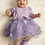 baby, infant, four_months, purple_dress, tutu, headband, smile, chubby_cheeks, socks, lying_down, blanket, props, portrait, studio_photo, cute, flower_decor, soft_lighting, celebration, accessory, adorable