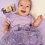 baby, infant, child, smiling, purple, headband, dress, tutu, floral_embroidery, stuffed_bunny, wooden_block, milestone_block, flowers, blanket, lying_down, portrait, close_up, cute, happy, accessory