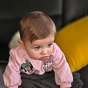 Alizya a rejoint le concours — aidez-le/la à gagner de superbes lots ! baby, child, crawling, pink_sweatshirt, minnie_mouse, daisy_duck, blanket, gray_blanket, yellow_pillow, couch, indoor, curious, face, hands, soft_texture, young_child, portrait, expression, clothing, person