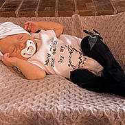 Georgia Ann is registered to the contest to win money with this photo: baby, sleeping, pacifier, headwrap, flower, white_onesie, black_socks, blanket, texture, infant, peaceful, indoors, resting, cute, small, child, cozy, soft, laying, comfortable