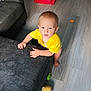 Robert is registered to the contest to win money with this photo: toddler, child, yellow_shirt, couch, indoor, floor, red_slide, toy, barefoot, curious, baby, playroom, wooden_floor, furniture, person, young_child, looking_up, climbing, home, casual