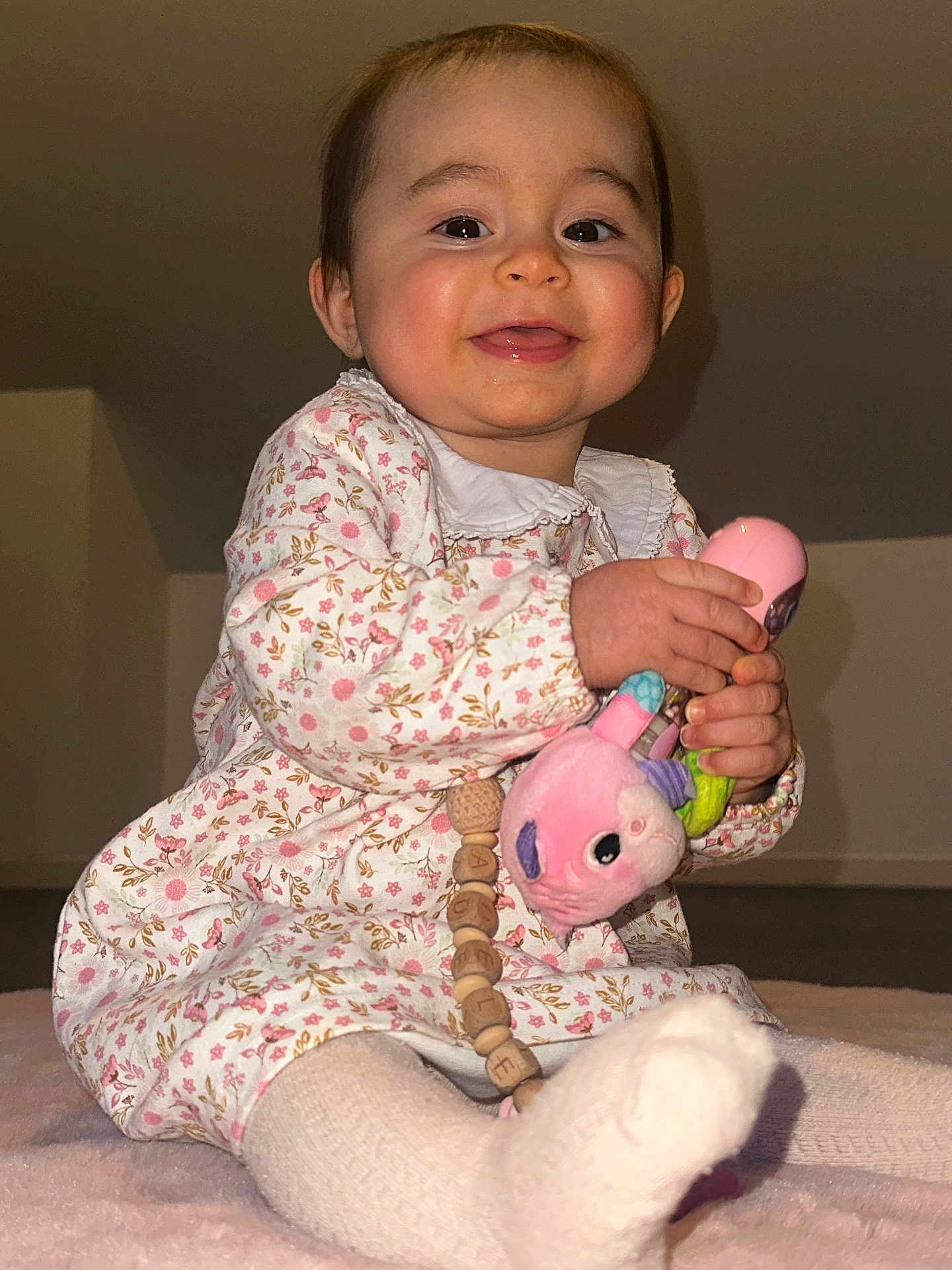 Adèle participe au concours pour gagner de l'argent avec cette photo : baby, child, smiling, toy, plush_toy, sitting, floral_dress, white_tights, happy, indoor, blanket, cute, face, person, young_child, playing, hands, feet, closeup, portrait