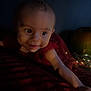 Adèle a rejoint le concours — aidez-le/la à gagner de superbes lots ! baby, infant, face, arm, red_dress, sparkle, fairy_lights, pumpkin, dark_background, cozy, curious, smiling, wide_eyes, soft_lighting, blanket, indoors, portrait, child, cute, holiday