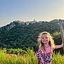Tessa a rejoint le concours — aidez-le/la à gagner de superbes lots ! blonde_hair, child, dress, fence, girl, greenery, happy, hill, landscape, nature, outdoor, plant, portrait, scenery, sky, smiling, summer, sunlight, village, wooden_post