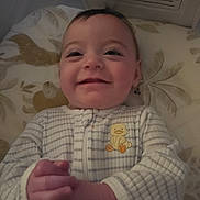Xena joined the competition — help win amazing prizes! baby, infant, smiling, pajamas, duck_patch, hands_clasped, lying_down, pillow, warning_label, face, cute, child, sleepwear, indoors, closeup, portrait, young_child, soft_lighting, expression, happy