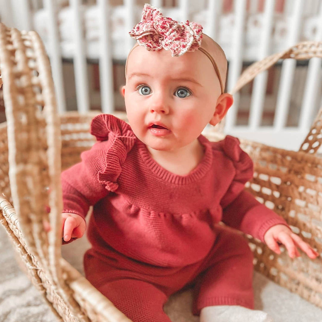 Maisyn is registered to the contest to win money with this photo: baby, baby_toddler_clothing, cheek, child, embellishment, eye, fashion_accessory, hair_accessory, happy, headband, headpiece, iris, jewellery, magenta, pattern, person, pink, sitting, skin, sleeve
