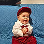 Luka Vucic a rejoint le concours — aidez-le/la à gagner de superbes lots ! accessory, baby, blue_background, bow_tie, cap, child, couch, cute, fashion, footwear, hands_clapped, happy, indoor, infant, playful, portrait, red_clothing, sitting, smiling, white_shirt