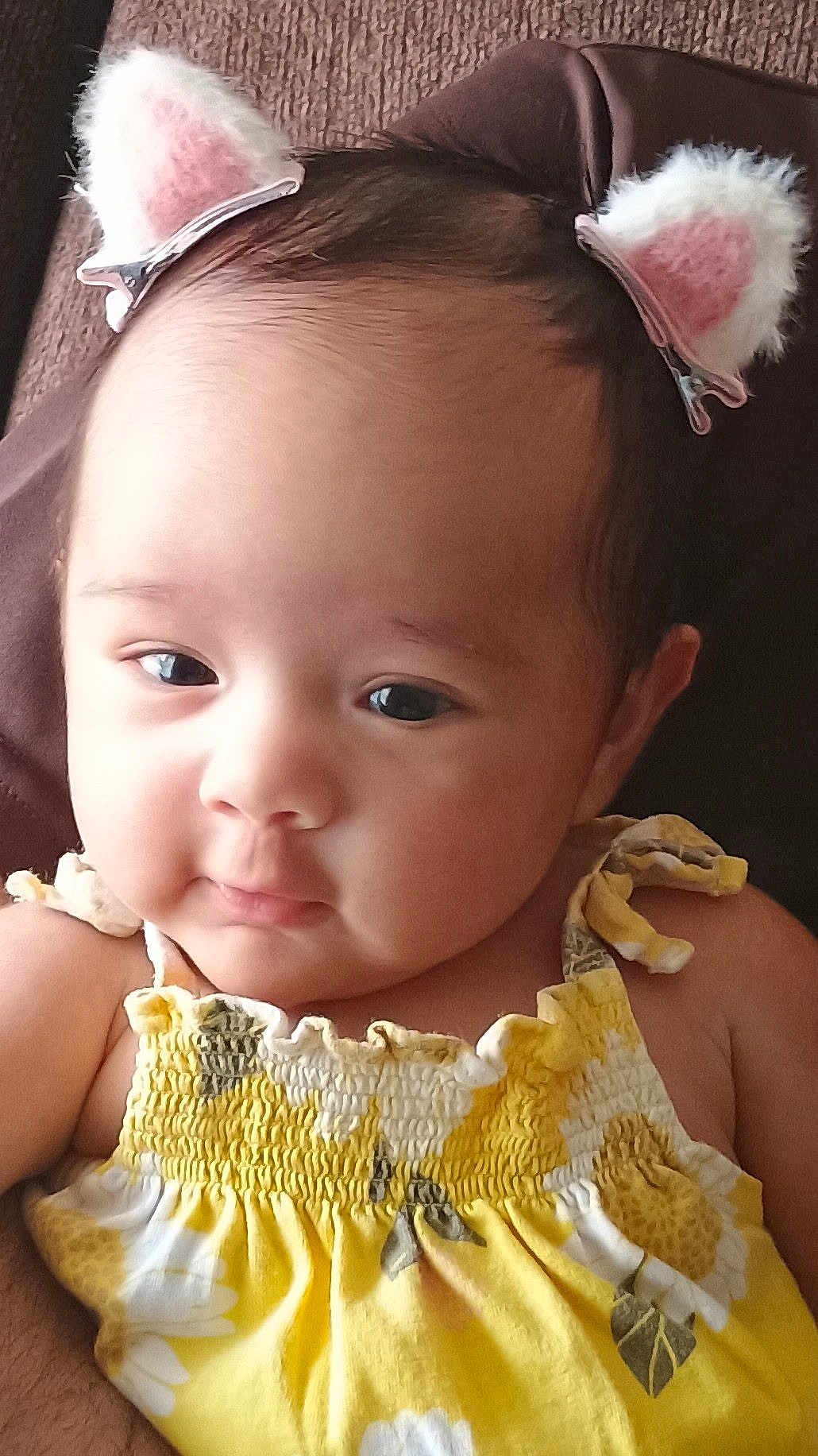 Celine joined the competition — help win amazing prizes! baby, child, face, portrait, yellow_dress, flower_pattern, headwear, cat_ears, hair_clip, cute, infant, closeup, skin, eyes, person, smile, indoors, soft_texture, clothing, young_child