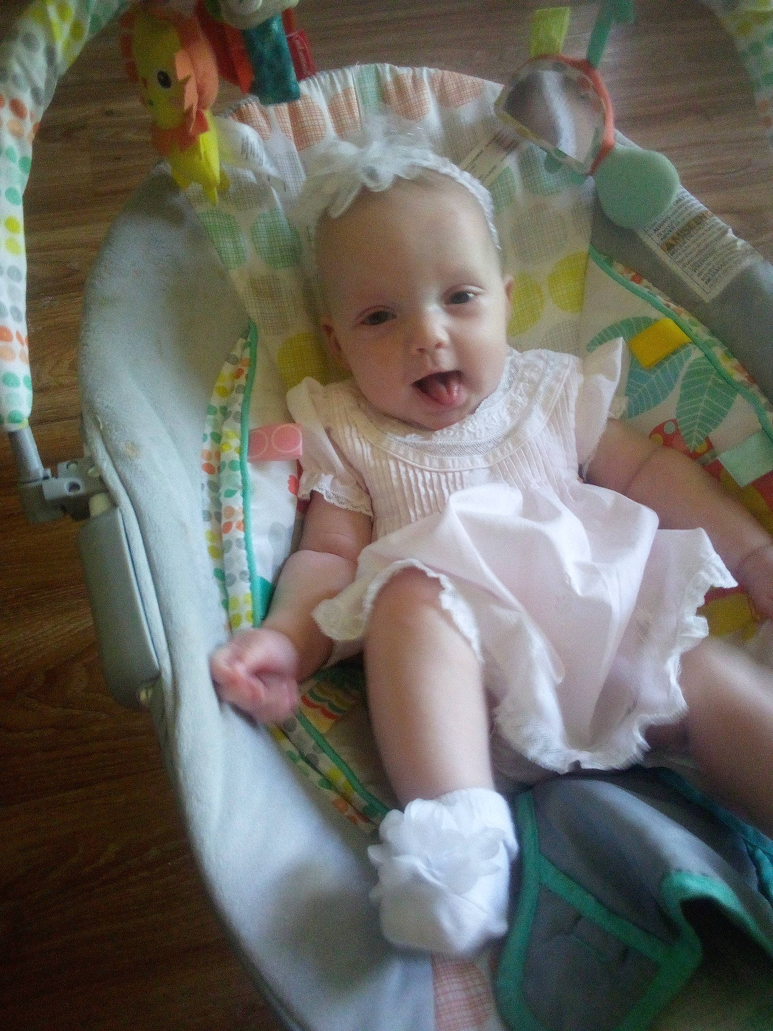 Arianna is registered to the contest to win money with this photo: baby, baby_products, baby_toddler_clothing, chair, cheek, child, comfort, dress, embellishment, event, fashion_accessory, happy, lap, person, pink, product, room, sitting, smile, sock