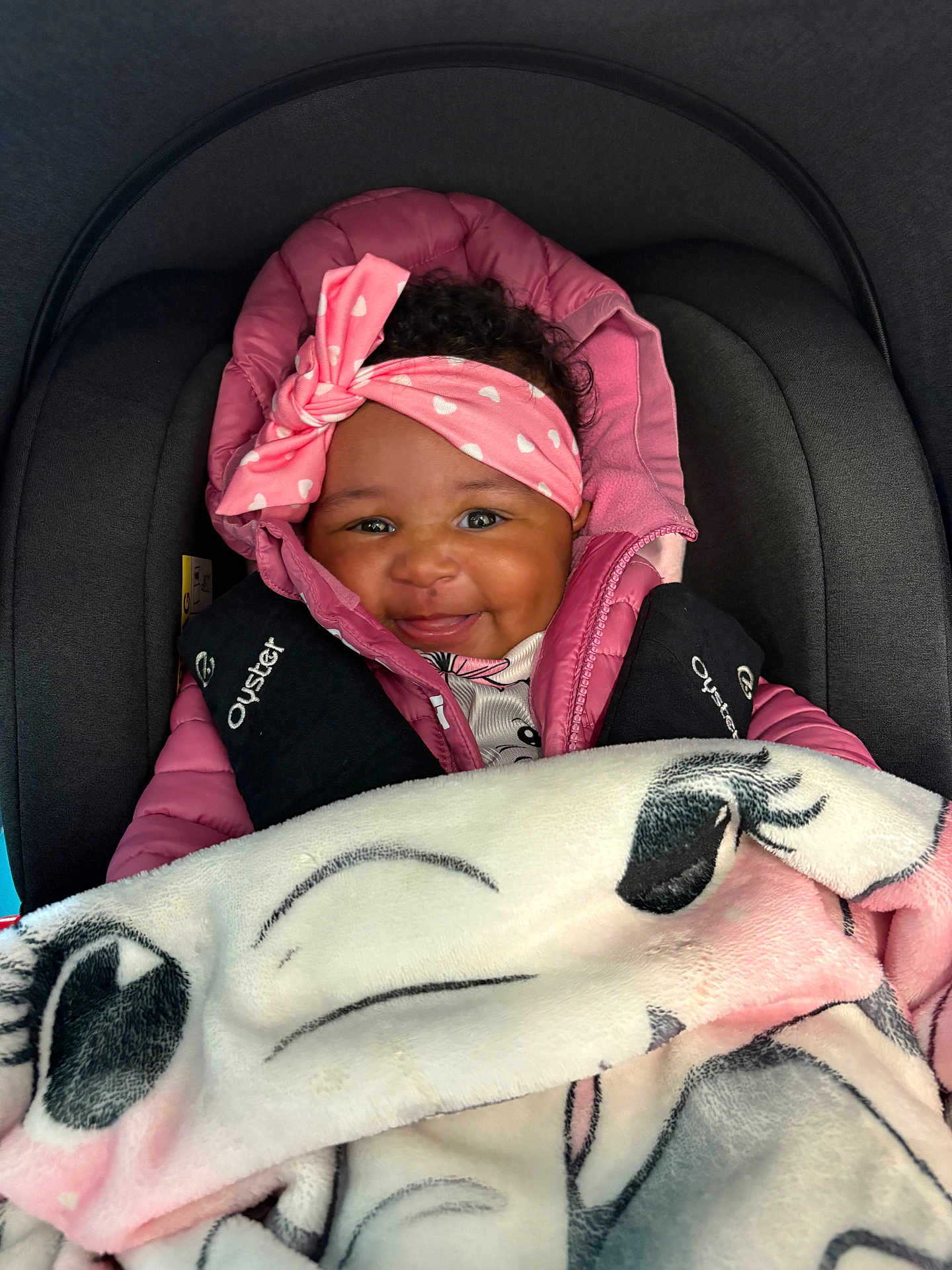 Anaiylah-Rea is registered to the contest to win money with this photo: baby, smile, headband, pink_jacket, blanket, car_seat, child, cozy, cute, infant, apparel, face, happy, indoors, person, portrait, seatbelt, warm, toddler, wrapped