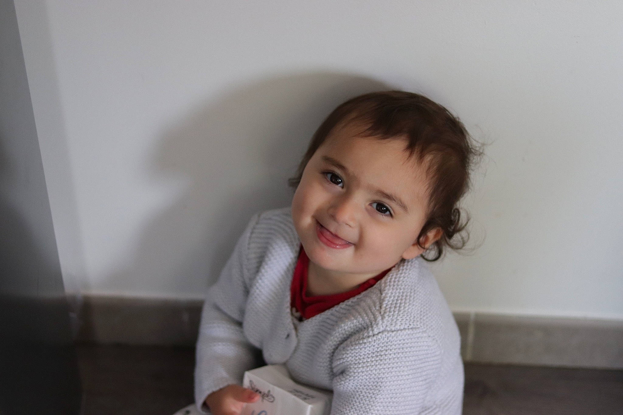 Alaïa participe au concours pour gagner de l'argent avec cette photo : baby, baby_toddler_clothing, cheek, eye, flash_photography, flooring, fun, happy, human_body, iris, joy, mouth, nose, person, room, sitting, skin, sleeve, smile, t_shirt