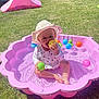toddler, child, pool, pink_pool, water, ball, colorful_balls, sun_hat, grass, outdoor, play, summer, sunny, toy, fun, baby, sitting, happy, daytime, garden