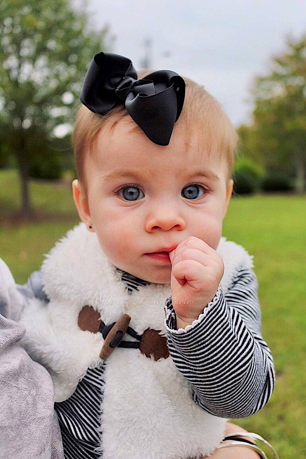 Ava Grace is registered to the contest to win money with this photo: baby, baby_toddler_clothing, cheek, child, cool, eye, face, fashion_accessory, finger, grass, hair_accessory, head, headgear, lip, mouth, nose, outerwear, person, photography, skin