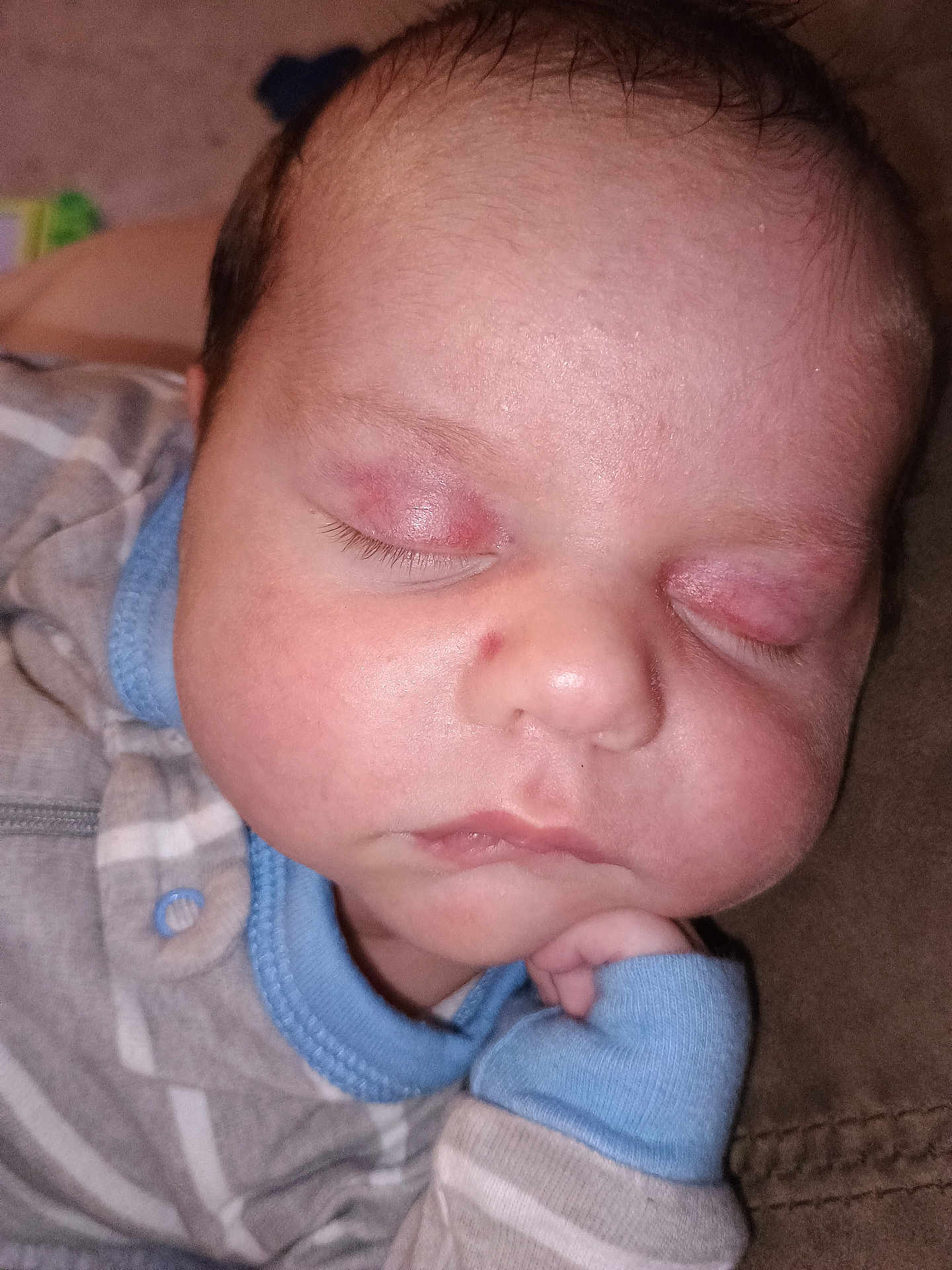 Cayden is registered to the contest to win money with this photo: baby, sleeping, close_up, face, infant, peaceful, resting, eyelids, mark, clothing, striped, blue_cuffs, soft_surface, skin, head, hand, cute, indoors, portrait, newborn