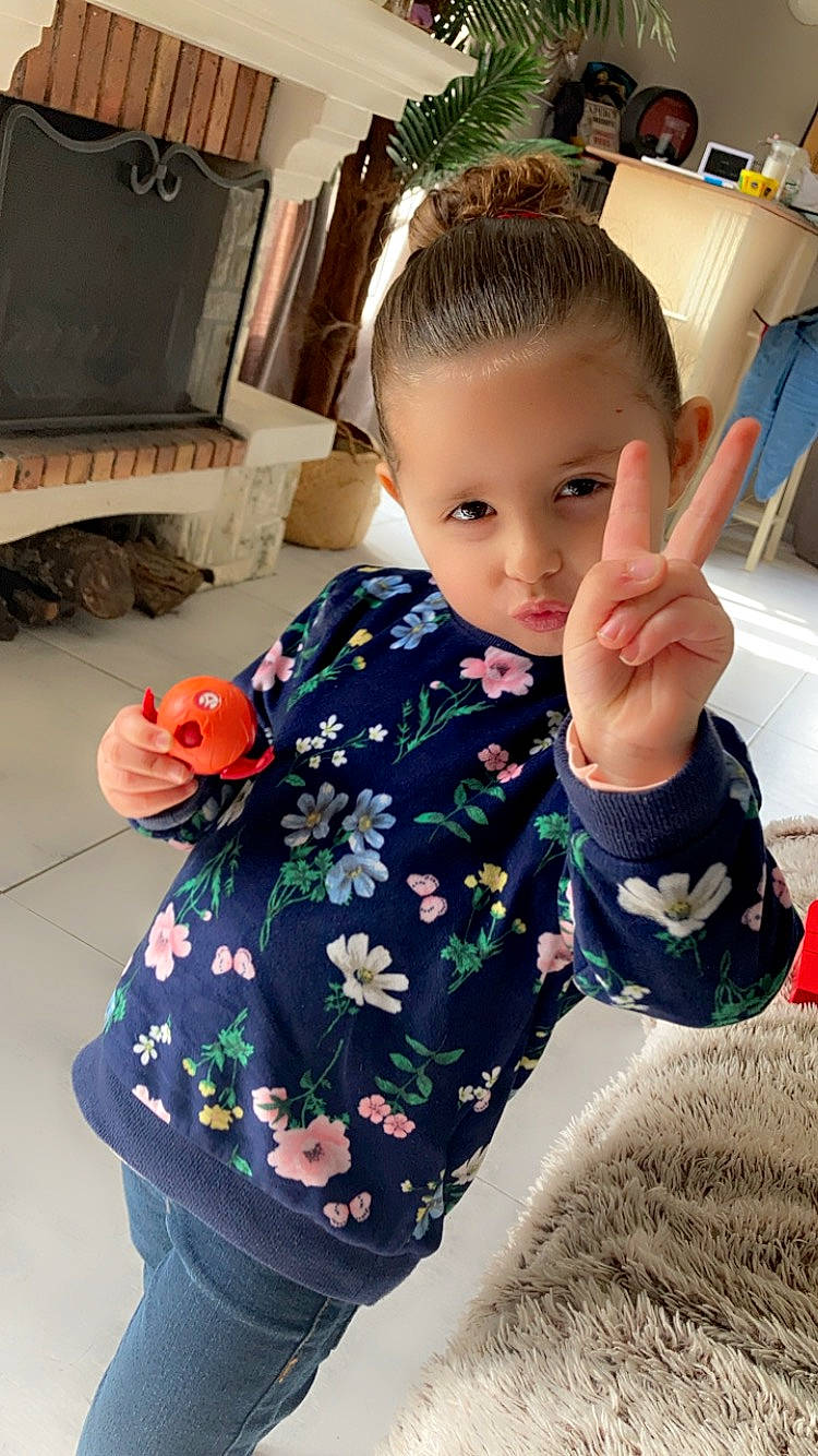 Zina participe au concours pour gagner de l'argent avec cette photo : baby, baby_toddler_clothing, child, facial_expression, flooring, gesture, hairstyle, happy, human_leg, neck, pattern, people, person, sitting, skin, sleeve, standing, t_shirt, thigh, thumb