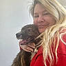 Nyla joined the competition — help win amazing prizes! woman, dog, hug, smile, happy, blonde_hair, pet, indoor, portrait, casual_clothing, red_jacket, friendly, closeup, animal, companionship, warmth, affection, light_background, long_hair, domestic_animal