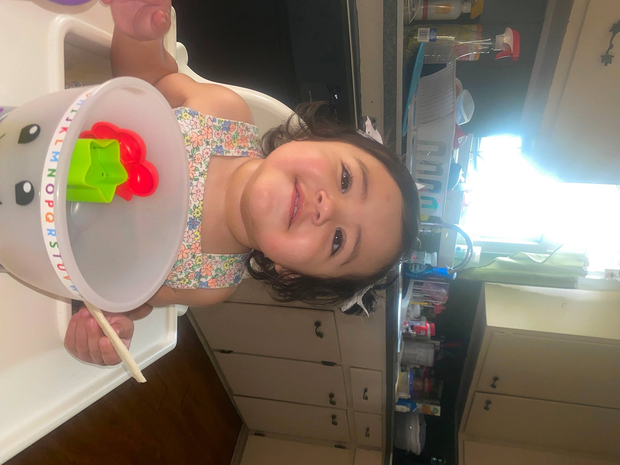 Dahlia is registered to the contest to win money with this photo: baby, cabinetry, child, drawer, electronic_device, eye, fun, happy, home_appliance, human_body, leg, machine, major_appliance, person, room, skin, smile, space, t_shirt, toddler