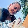 Oréo a rejoint le concours — aidez-le/la à gagner de superbes lots ! animal, black_jacket, blue_eyes, braids, chain_necklace, closeup, cute, dog, earrings, friendship, happy, outdoor, patterned_dress, pet, portrait, sky, smile, sunlight, tree, woman