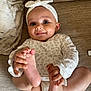 baby, infant, smiling, playful, headband, leopard_print, feet, hands, couch, blanket, clothing, happy, person, skin, indoors, cute, young_child, portrait, sitting, cozy