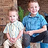 children, brothers, boys, portrait, smiling, sitting, porch, brick_wall, outdoor, spiky_hair, blue_shirt, striped_shirt, boots, sneakers, plant, home, family, casual_clothing, young, happy