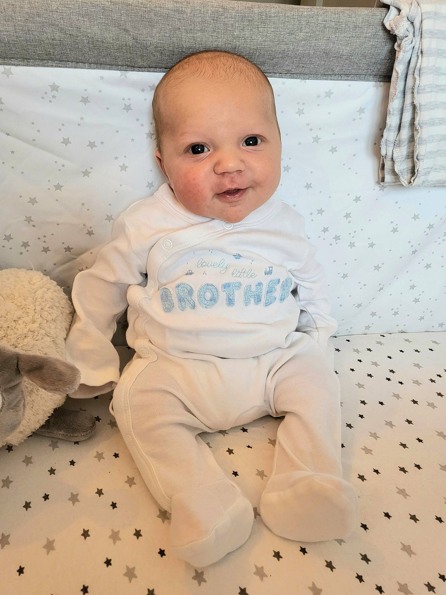 Jack is registered to the contest to win money with this photo: baby, baby_toddler_clothing, cheek, child, comfort, floor, flooring, foot, happy, linens, pattern, person, portrait_photography, product, room, sitting, skin, sleeve, smile, toddler