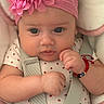 baby, infant, child, portrait, close_up, face, eyes, pink, headband, flower, smiling, outdoor, seated, baby_carrier, straps, clothing, strawberry_pattern, bracelet, cushion, photography