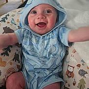 Otto joined the competition — help win amazing prizes! baby, child, blue_clothing, hoodie, smiling, happy, indoor, cushion, animal_print, pattern, cute, infant, person, sitting, reaching, playful, face, eyes, mouth_open, joyful