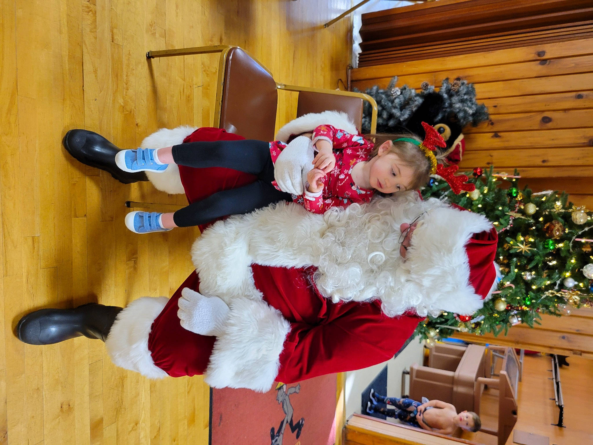 Aurora is registered to the contest to win money with this photo: christmas_ornament, christmas_tree, costume, costume_hat, event, fictional_character, fun, fur, happy, hat, holiday, lap, person, plant, room, santa_claus, sock, thigh, tradition, tree