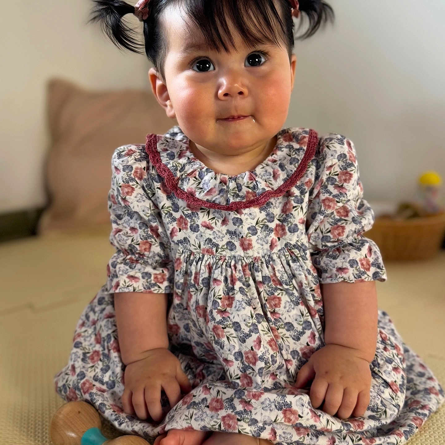 Aya joined the competition — help win amazing prizes! adorable, baby, barefoot, big_eyes, child, chubby_cheeks, cushion, feet, floral_dress, hair_bows, hands, indoor, pigtails, playmat, portrait, sitting, smile, toddler, toy, wooden_toy