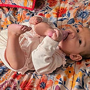 Rinoa joined the competition — help win amazing prizes! baby, infant, foot, hand, blanket, floral_pattern, lying_down, clothing, cute, face, skin, person, indoors, comfort, playful, young_child, expression, looking, colorful, bedspread