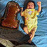 Valerie is registered to the contest to win money with this photo: baby, infant, yellow_onesie, blue_blanket, chocolate_cake, number_one_cake, sprinkles, celebration, birthday, cake_pan, lying_down, raised_arm, cute, sleepy, indoors, floor, wooden_floor, portrait, person, food