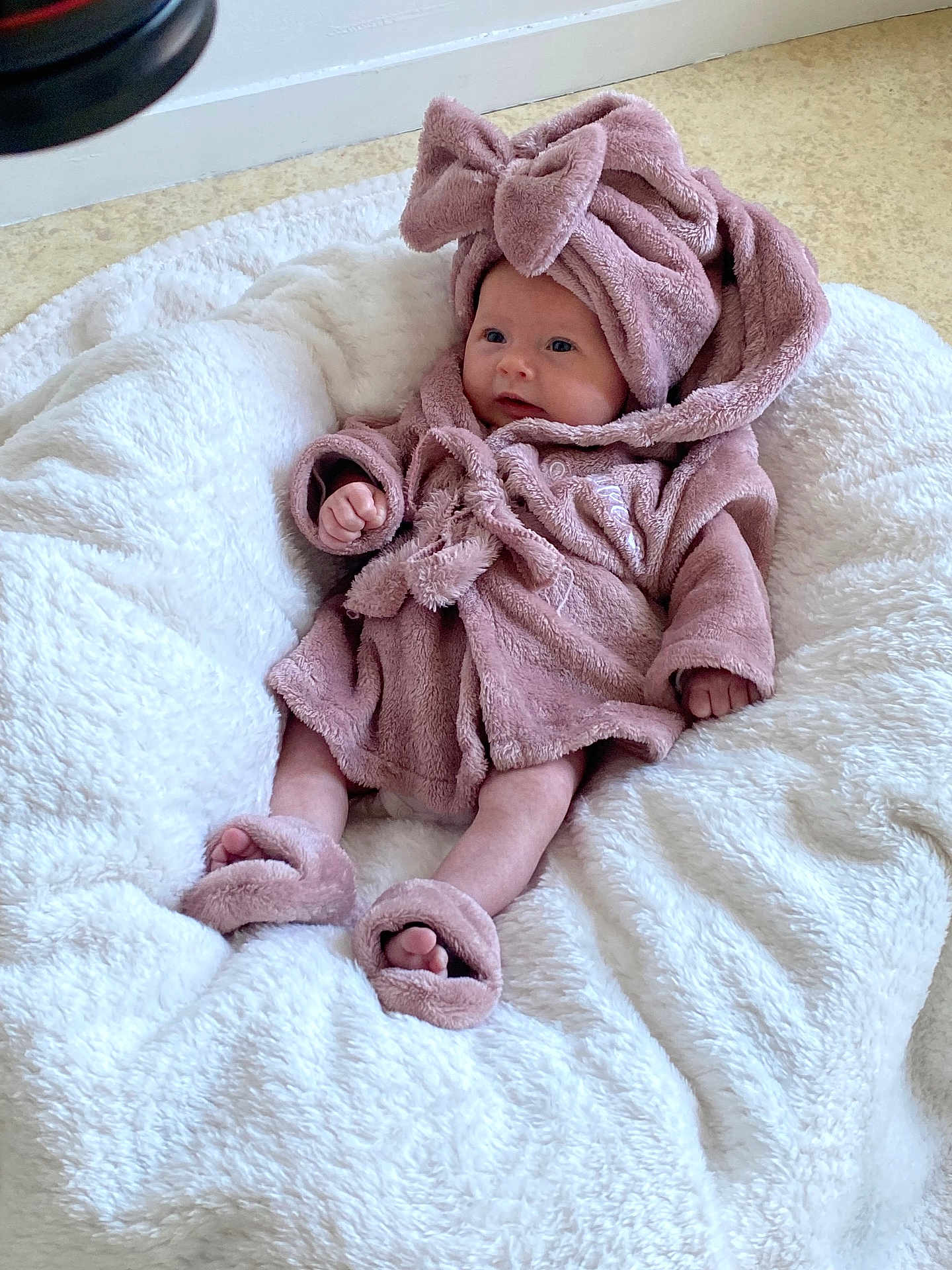 Adelle a rejoint le concours — aidez-le/la à gagner de superbes lots ! baby, infant, soft_toy, blanket, cushion, robe, headband, slippers, pink, white, floor, indoors, child, cute, cozy, plush, comfort, smile, face, person