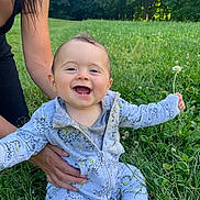 Tiago participe au concours pour gagner de l'argent avec cette photo : adult_hand, baby, child, cute, daylight, flower, forest, grass, greenery, happy, holding, infant, nature, onesie, outdoor, person, playful, sitting, smiling, sunlight