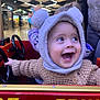 Tiago participe au concours pour gagner de l'argent avec cette photo : adult, amusement_ride, baby, bear_hood, candid, child, hand_on_wheel, hat, indoor, joyful, knit_sweater, laughing, person, red_car, shopping_mall, smiling, sparkly_lights, steering_wheel, toddler, toy