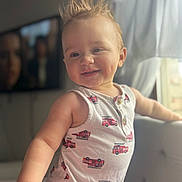 Kai is registered to the contest to win money with this photo: toddler, child, smiling, indoor, curtain, couch, clothing, fire_truck_pattern, hair, face, arm, window, light, portrait, happy, person, baby, sleeveless, cute, expression
