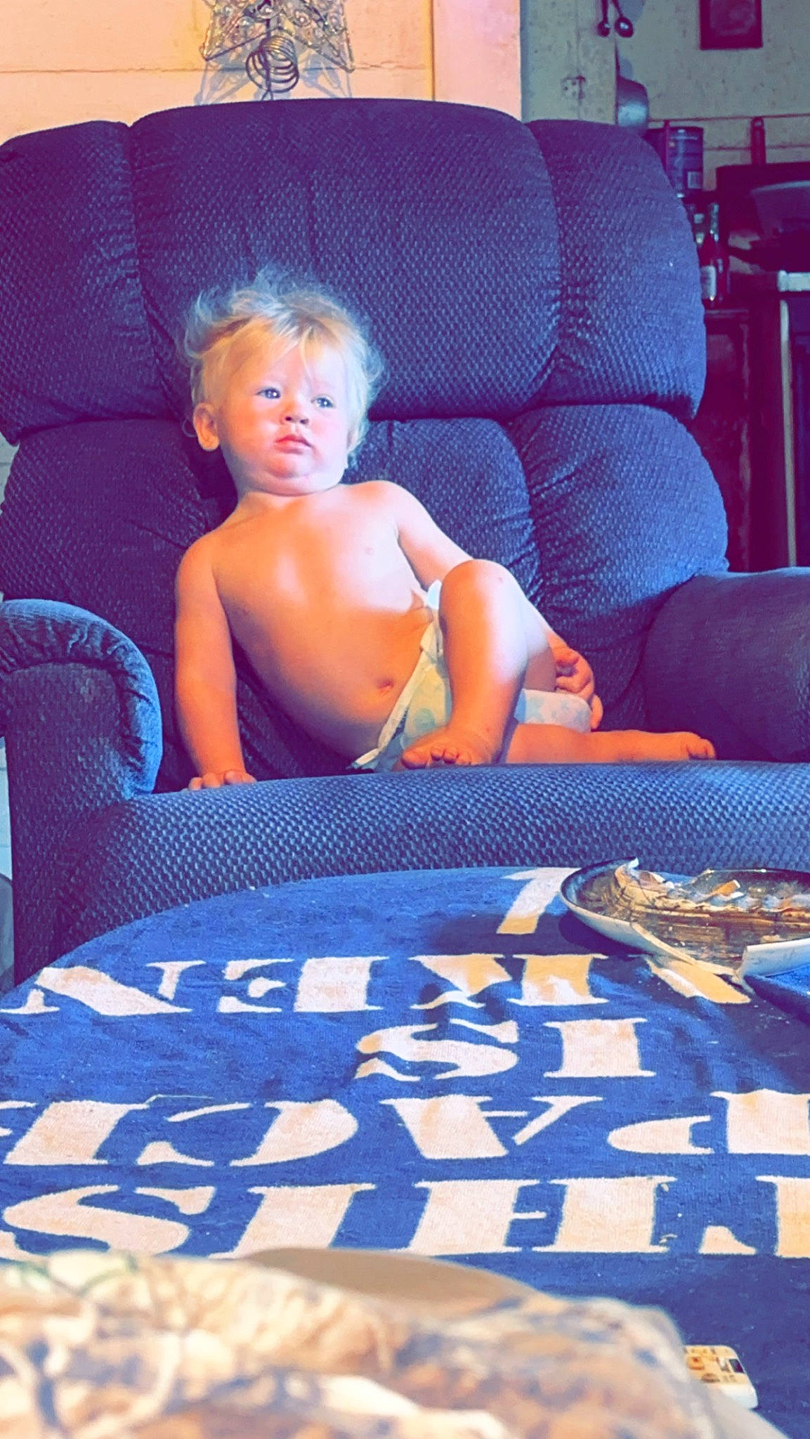 Jaymeson is registered to the contest to win money with this photo: azure, barechested, chest, comfort, cool, couch, electric_blue, floor, flooring, fun, furniture, human_leg, leisure, linens, living_room, person, purple, room, sitting, thigh