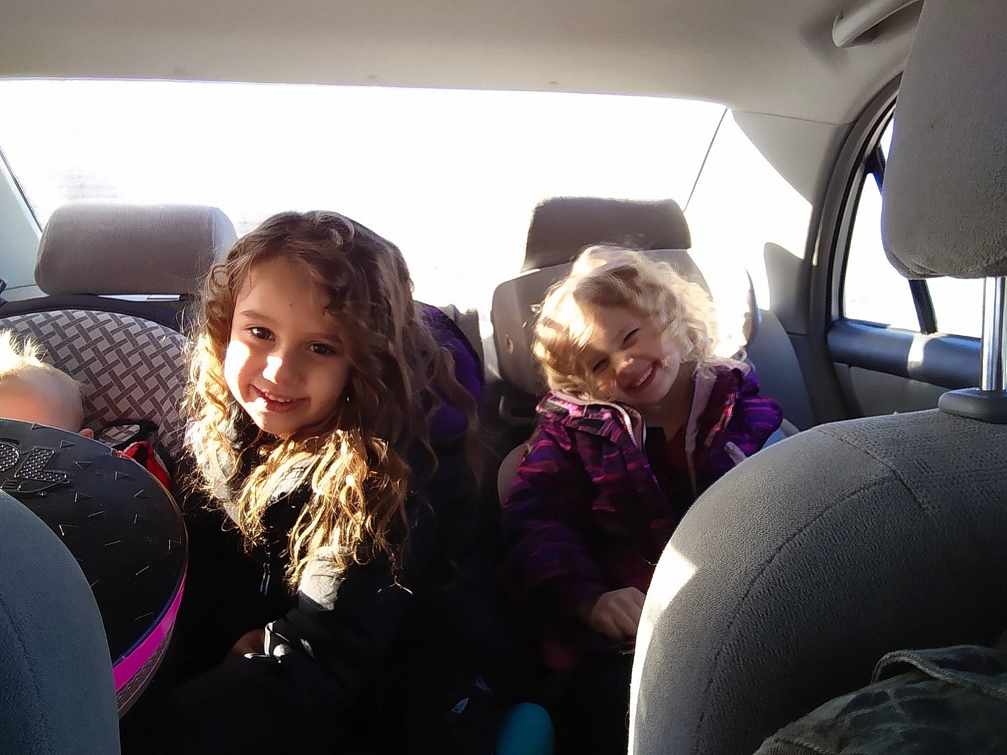 Arielle is registered to the contest to win money with this photo: air_travel, auto_part, automotive_design, automotive_exterior, car, car_seat, car_seat_cover, comfort, family_car, fun, head_restraint, joy, mode_of_transport, motor_vehicle, passenger, person, purple, smile, toddler, vehicle