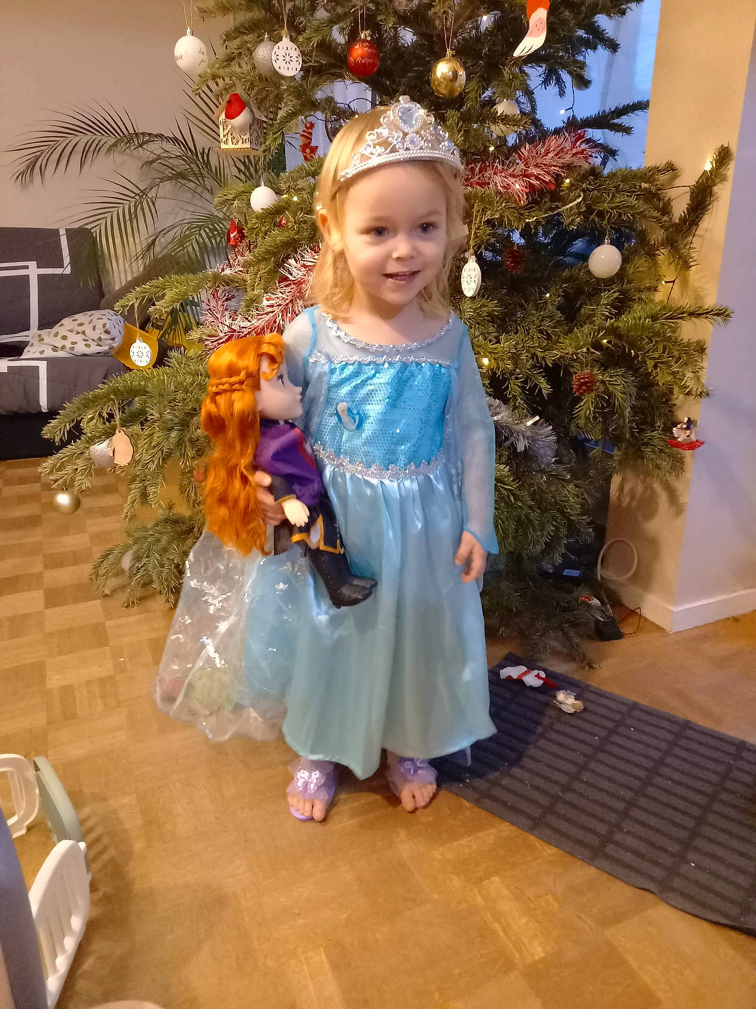 Justine participe au concours pour gagner de l'argent avec cette photo : baby_toddler_clothing, christmas, christmas_decoration, christmas_ornament, christmas_tree, dress, event, evergreen, flooring, happy, holiday, holiday_ornament, human_body, joy, ornament, person, plant, smile, toddler, tree