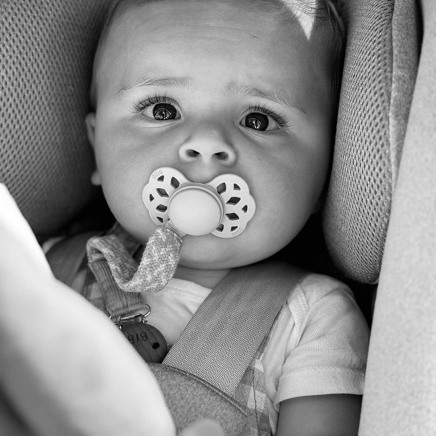 Eden a rejoint le concours — aidez-le/la à gagner de superbes lots ! baby, black_and_white, car_seat, child, child_safety, close_up, clothing, curious_eyes, cute, expression, face, head_support, indoors, infant, pacifier, portrait, safety_harness, seat_belt, soft_texture, young_child
