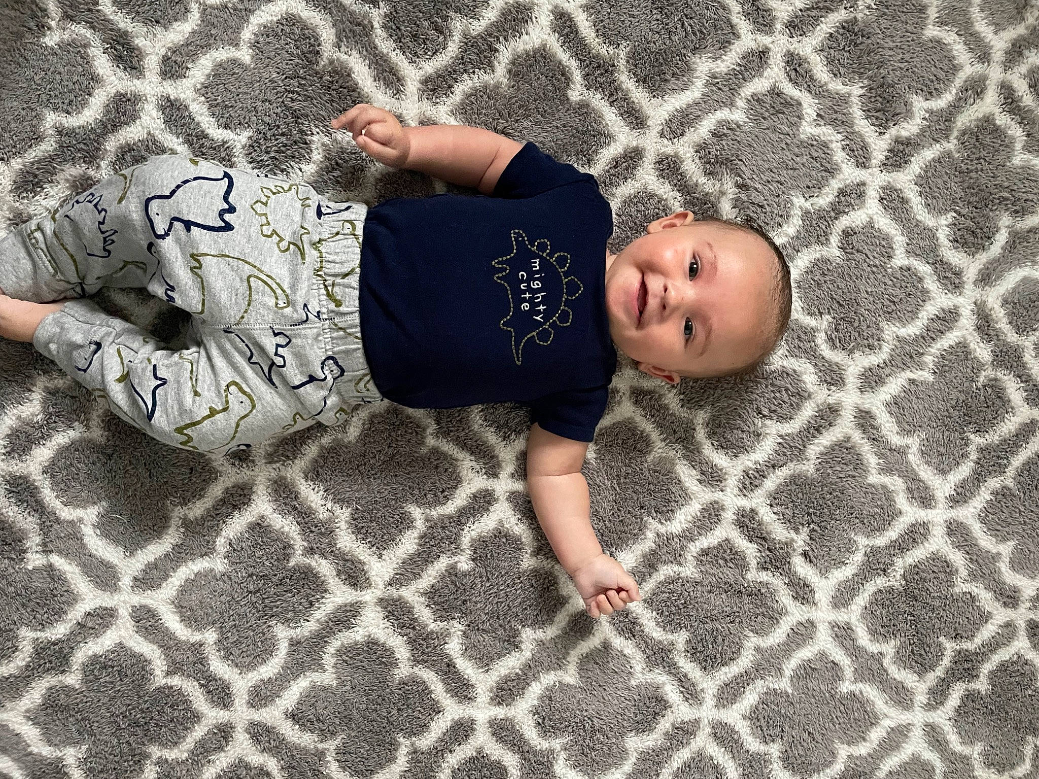 Kamden joined the competition — help win amazing prizes! baby, baby_toddler_clothing, child, comfort, finger, floor, flooring, font, fun, grass, hardwood, human_leg, joy, leg, pattern, person, room, shadow, sitting, t_shirt